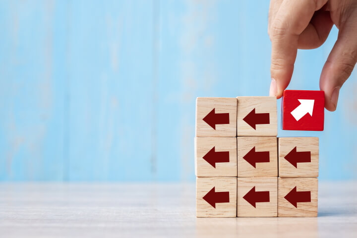 hand placing red block with different direction arrow