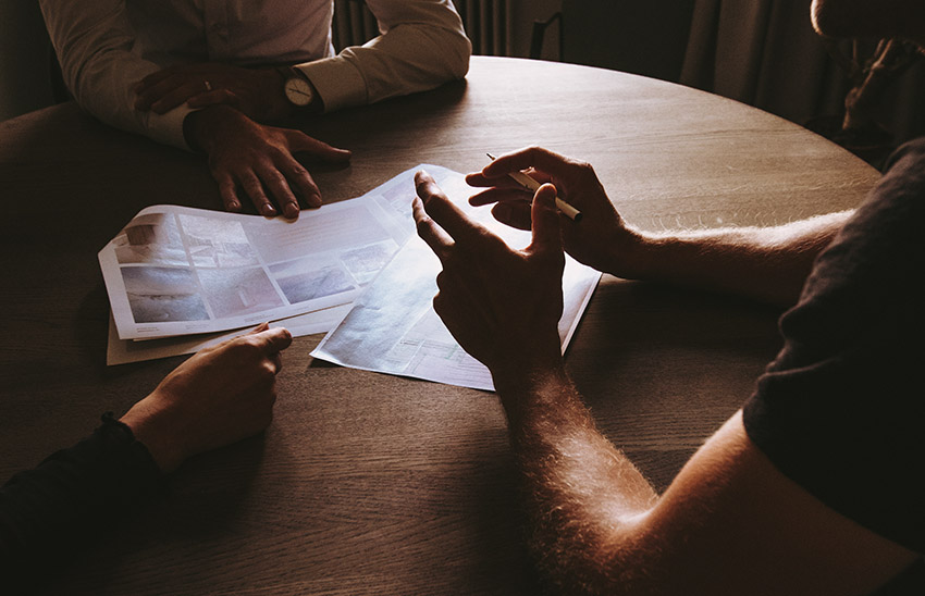 Three people sitting at a desk having a discussion