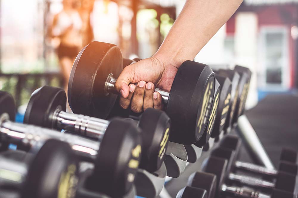 hand picking up a weight at a gym